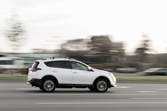 The white Toyota Rav 4 is driving on the street at high speed. Motion blur. Riga, Latvia - 07 Oct 2021