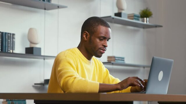 Young man surfing the internet using laptop ast home. Young man with laptop