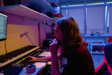 Fototapeta na wymiar Male composer smoking cannabis and making music