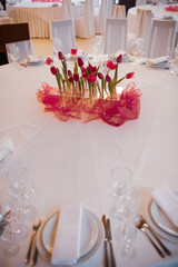 Festive table setting with candles and flowers. pink tulips