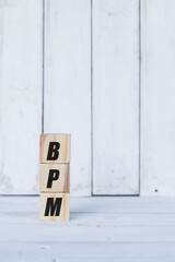 bpm concept written on wooden cubes or blocks, on white wooden background.