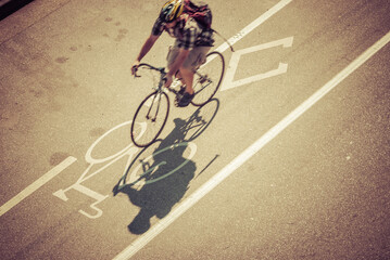 Above view of anonymous cyclist riding in a designated bicycle lane in an urban city.