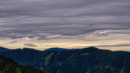 Obraz premium Mystical clouds and scenic view from mount Roethelstein near Mixnitz in Styria, Austria. Landscape of green alpine meadow and bushes in the valley of Grazer Bergland in Styria, Austria. Cloudscape