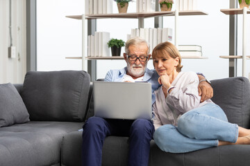 Obraz premium senior couple using laptop computer on sofa