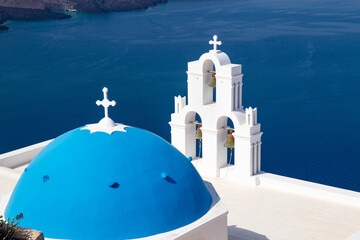 Three Bells of Fira with blue domed church, Santorini island, Greece