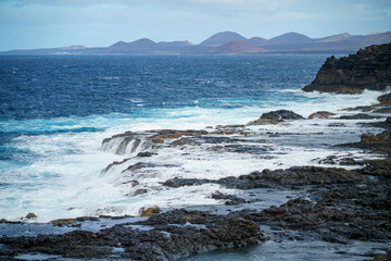 Fototapeta na wymiar Waves breaking on the rocks in natural areas of the island of Lanzarote in the Canary Islands