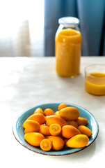 Kumquats on blue plate with citrus juice