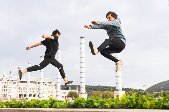 Energetic men leaping during a parkour training on street