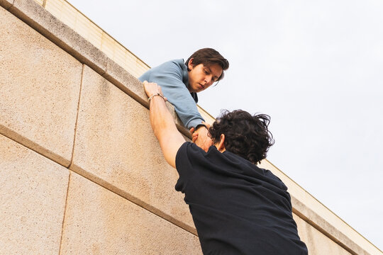 Man holding hand of man on building