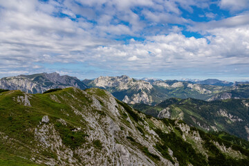 Obraz premium Panoramic view from Messnerin on the alpine mountain chains in Styria, Austria, Hochschwab region. Hills overgrown with small bushes, higher parts rocky and bare. Summer day. Hiking in Alps, Tragoess
