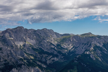 Panoramic view on the alpine mountain chains in Styria, Austria, Hochschwab region. Hills overgrown with small bushes, higher parts rocky and bare. Sunny summer day. Serenity. Hiking in Alps, Tragoess