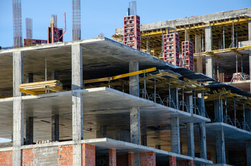 Construction site background. Hoisting cranes and new multi-storey buildings. Industrial background. brick building.