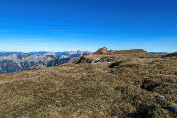 Hiking trail leading to mount Eisenerzer Reichenstein in Styria, Austria, Europe. Austrian Alps. Bare mountain ridges of Ennstal Alps with view on the Reichensteinhuette. Summit cross on the peak
