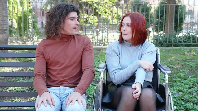 furtive kiss - shy man kisses his friend with paraplegia at the park