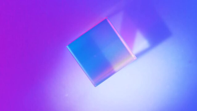 Optical glass with neon lighting. Blurred background with geometric shapes, soft selective focus. Light refraction concept.