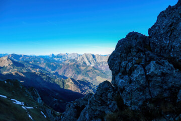 Obraz premium Massive cliff in the shadows of mount Eisenerzer Reichenstein in Styria, Austria, Europe. Austrian Alps. Mountain ridges of the Ennstaler Alps. Kaiserschild in the distance. Hiking trail, Wanderlust