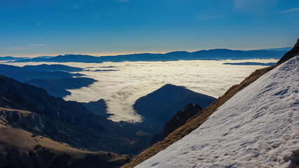 A panoramic view from mount Eisenerzer Reichenstein (2165m) near Eisenerz in Styria, Austria, Europe. Austrian Alps. The Ennstal valley is covered in clouds and fog. Hiking trail,Wanderlust. Sunny day