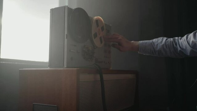 Secret agent spinnin the reel tape recorder. Officer wiretapping in headphones. KGB spying of conversations. Cold war concept.