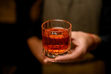 selective focus of old-fashioned glass with cold alcoholic drink in male hand