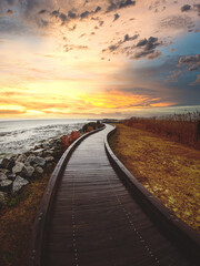 Boardwalk by the water heading into the sunset