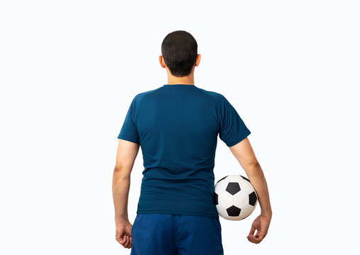 Cropped rearview image of a young player man holding a soccer ball under his arms at Paris.Rearview