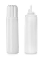 Bottles of delicious whipped cream on white background