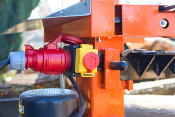 Close-up shot of a emergency switch on a hydraulic wood splitter