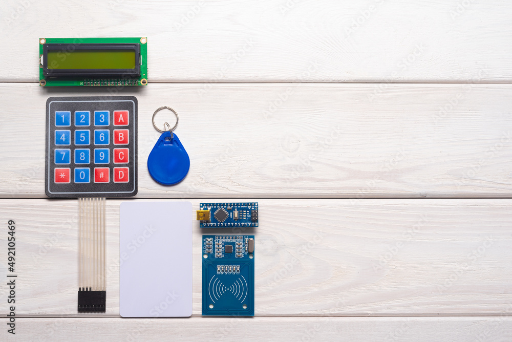 Wall mural door access control keypad, magnetic key, card and display on the white background with copy space.