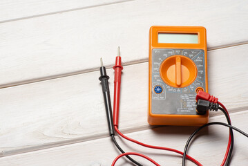 Electric multimeter on the wooden table top view background with copy space.
