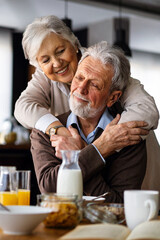 Senior happy couple in love together smiling and having fun in kitchen