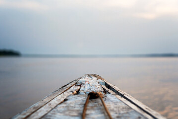 Shallow depth of field image, front of boat / canoe in Amazon River at sunrise