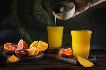 Glass of fresh orange juice with fresh fruit on a wooden table Still life with fresh orange juice...