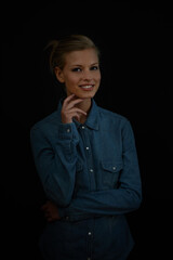 Positive thoughts brighten up a dark world. A young woman standing with her hand on her chin wearing a denim shirt.