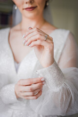 THE BRIDE IN A WEDDING DRESS WITH A RING ON HIS HAND
