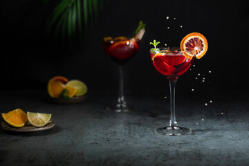 Refreshing sangria or punch with citrus orange lemon fruit in glasses . Sangria of red wine with ice. Traditional Spanish sangria . Drops from a squeezed orange