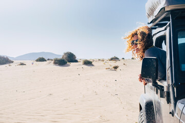 Happy travel woman smile and enjoy outdoors outside her black parked off road car. Summer vehicle holiday adventure. Alternative tourist in the desert with all terrain vehicle. People lifestyle © simona