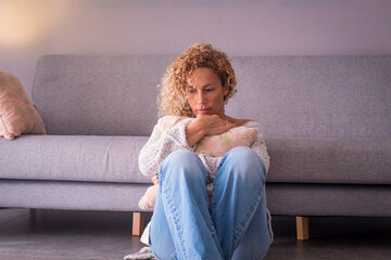 Sad and depression illness concept with woman sitting on the ground alone at home looking on the...