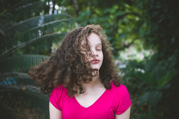 Portrait of serene young woman with eyes closed shaking hair