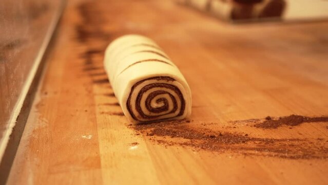 Baker working with handmade pastries in small bakery. Cocoa snail roll, chocolate roll. Closeup video of not staged, authentic moment.