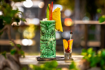 Tropical tiki cocktail on the bar with fruits.