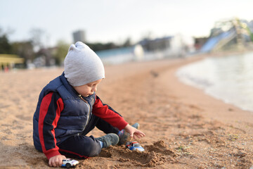 A child playing in the sand by the sea