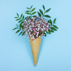 Cute flowers in the waffle cone on blue background.