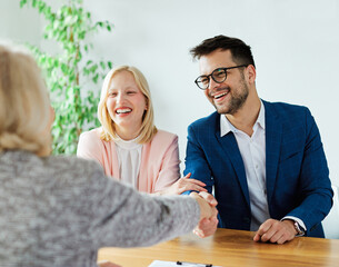 young couple shaking hands deal contract real estate investment business agreement agent handshake...