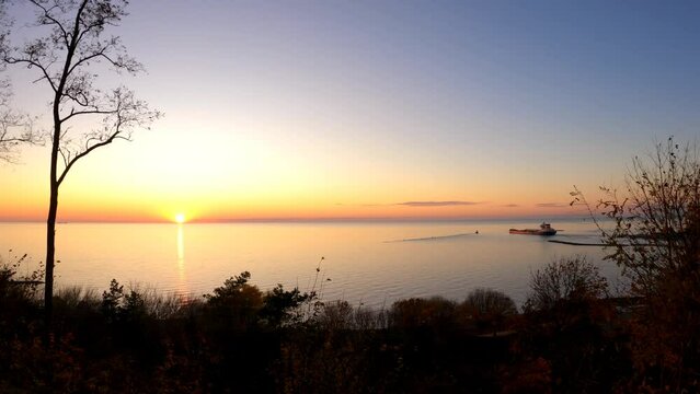 Bulk cargo ship sailing on water of Lake Huron in sunset