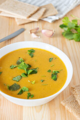 Red lentil creamy soup served with parsley and crispbread. Homemade vegetable warm food. - obrazy, fototapety, plakaty