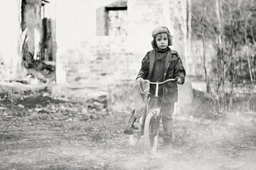 Child and war. Little, poor boy in the ruins of a bombed house.