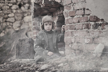 War and the child. Little scared boy in the ruins of the house.

