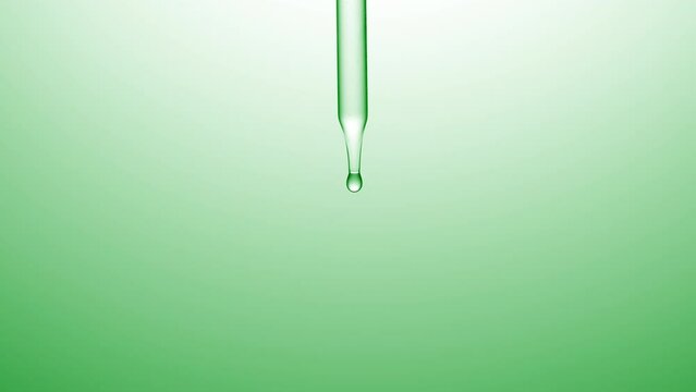 Macro shot of clear drops are falling down from chemical dropper on green background | Abstract skincare lotion ingredients formulation concept