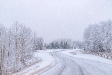 Fototapeta na wymiar Snow Falling Over A Wintry Road