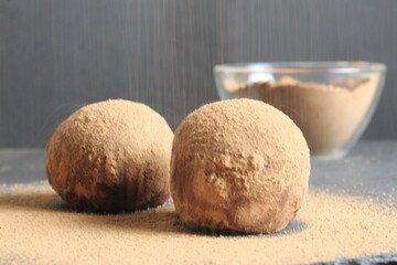 chocolate cake dessert in the shape of a ball of a circle sprinkled with cocoa powder. homemade dessert day of chocolate sweet tooth. a day without diet